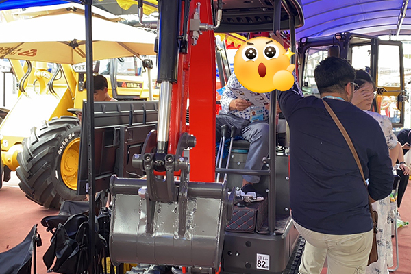 Skid steer loader consultation at heavy equipment trade fair booth